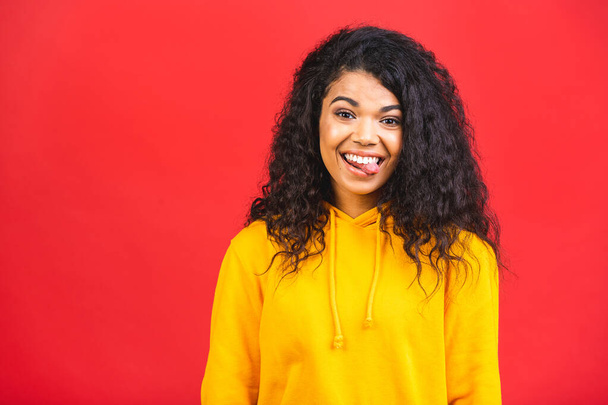 Portrait of beautiful positive african american black curly woman standing isolated over red background.  - Photo, Image