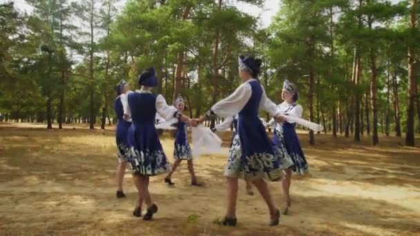 Seis mujeres jóvenes en trajes populares tradicionales rusos están bailando en el bosque de verano - Imágenes, Vídeo