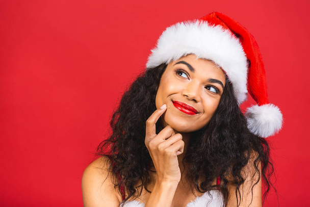 Linda sorrindo feliz afro-americana negra em roupas de Papai Noel isolado sobre fundo vermelho. Ano Novo e conceito de Natal.  - Foto, Imagem