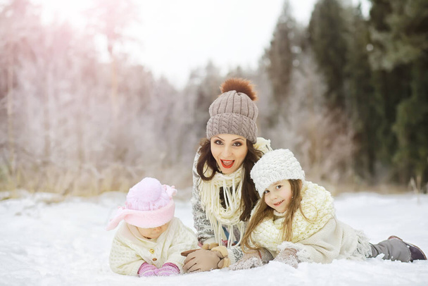 Glückliche Familie spielt und lacht im Winter draußen im Schnee. Wintertag im Stadtpark - Foto, Bild