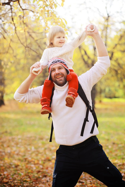 Junge Familie bei einem Spaziergang im Herbstpark an einem sonnigen Tag. Das Glück, zusammen zu sein. - Foto, Bild