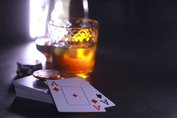 Glücksspiel-Kartenspiele für Geld. Texas Hold 'em Poker. Karten in der Hand, Spielchips, Kartenstapel mit Alkohol im Glas. - Foto, Bild