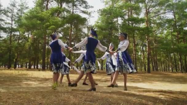 Seis mujeres jóvenes en trajes populares tradicionales rusos están bailando en el bosque de verano - Imágenes, Vídeo