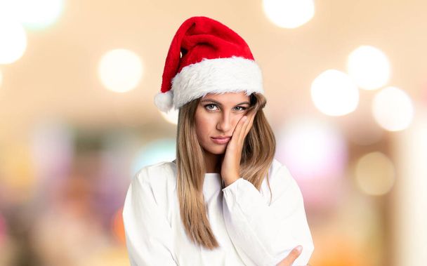 Lány a karácsonyi kalap boldogtalan és frusztrált a koncentrálatlan háttér - Fotó, kép