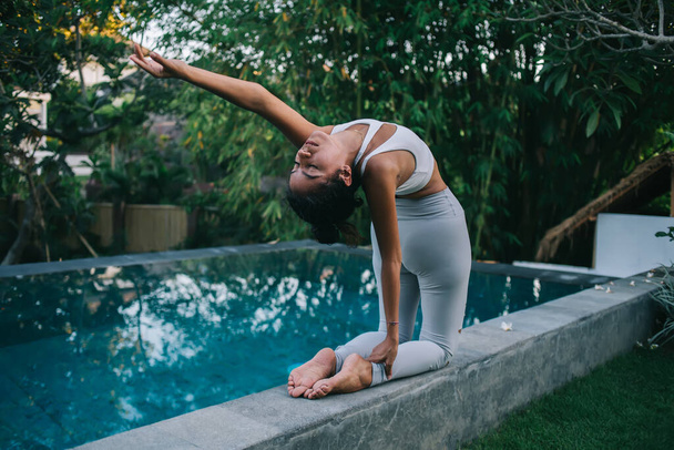Sottile femmina in pratica di usura attiva stretching posa yoga godendo il tempo libero respirazione e ricreazione, consapevolezza donna facendo asana esercizio sensazione di calma e benessere raggiungere l'armonia del corpo - Foto, immagini
