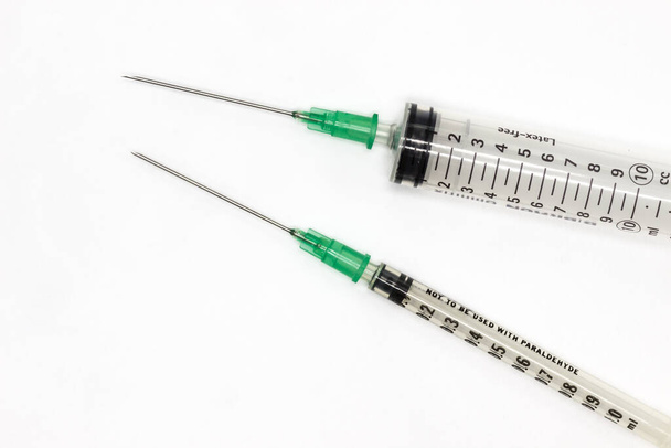 Aghi ipodermici su sfondo bianco. Molle per la vaccinazione durante la pandemia di coronavirus - Foto, immagini