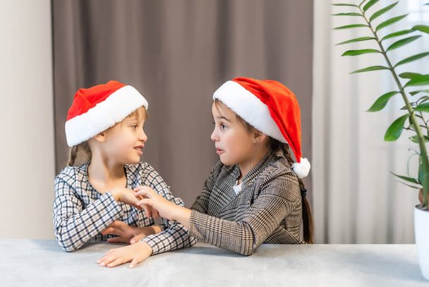 Karácsony Boldog vicces gyerekek ikrek nővérek télapó kalap - Fotó, kép