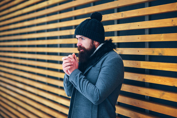 Bearded man in stylish coat and black hat. Outdoor portrait of handsome man in winter outfit. Male winter fashion. Lifestyle, people and winter. Cold winter weather. - Foto, Imagem