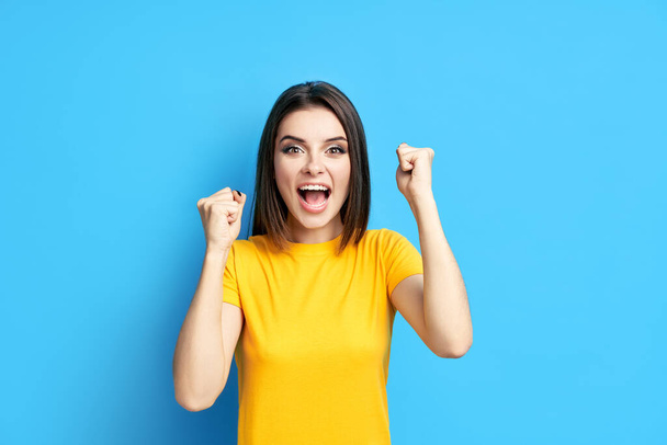 Happy excited young woman celebrate success with hands up - Foto, imagen