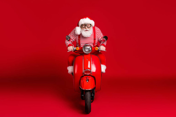 Portrait of his he handsome concentrated focused bearded Santa father riding moped North Pole delivery journey fast speed hurry rush trip isolated bright vivid shine vibrant red color background - Foto, immagini