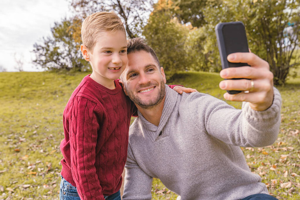 family father taking selfie by smartphone in autumn park - Zdjęcie, obraz