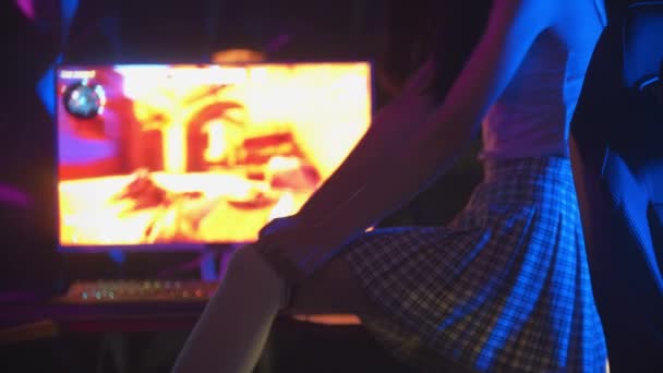 Молодая сексуальная женщина в компьютерном клубе и подтягивает носки для гольфа - садится в кресло и надевает наушники - Кадры, видео