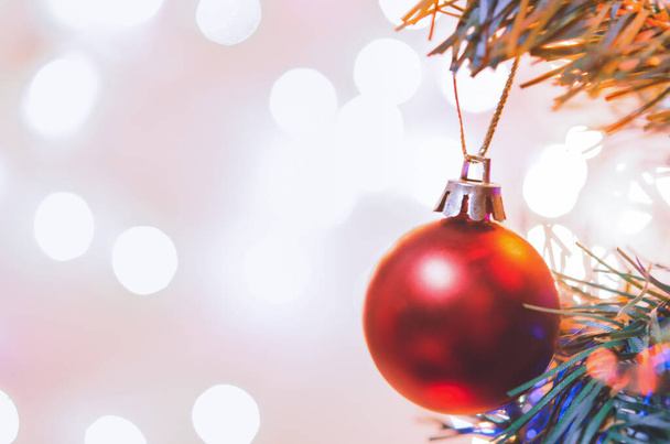 クリスマスの装飾。松の枝に吊るされた赤い玉クリスマスツリーガーランドと抽象的なボケの背景に装飾。 - 写真・画像