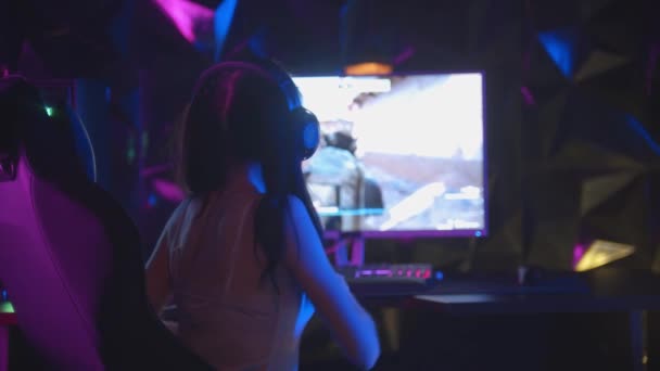 Mujer joven jugando un juego de ordenador - gana y se pone feliz - poner las manos en alto y mirando a la cámara con la cara sonriente - Imágenes, Vídeo