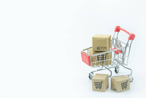 Einkaufskonzept - Kartons oder Papierschachteln in rotem Warenkorb auf weißem Hintergrund. Online-Shopping Verbraucher können von zu Hause und Lieferservice einkaufen. mit Kopierspac - Foto, Bild