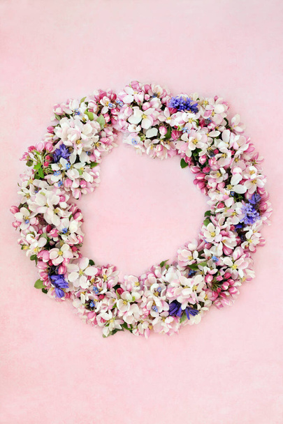 Wreath of spring flowers with apple blossom, bluebells & forget me nots on mottled pink background.  - Fotó, kép
