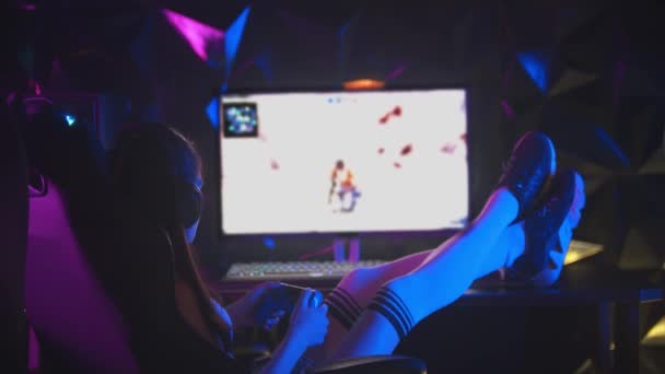 Jonge aantrekkelijke vrouw spelen games in gaming club met haar benen op de tafel - Video