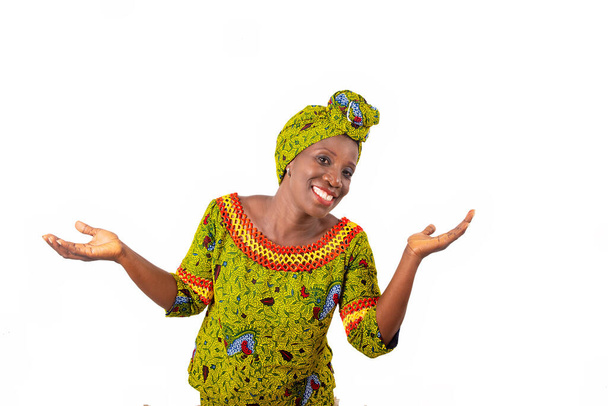 Krásná africká dospělá žena v bederní roušce a zelený šátek v hlavě s rukama a rukama zvednutýma s úsměvem - Fotografie, Obrázek