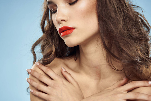 Brunette naakte schouders rode lippen modieuze kapsel blauwe achtergrond - Foto, afbeelding