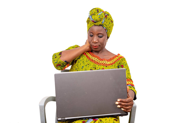 beautiful mature woman sitting in traditional dress on white background looking at laptop. - Photo, Image