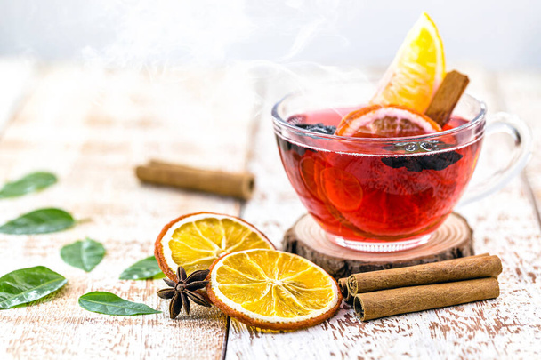 hot winter drink, with smoke and steam, hot Christmas wine, drink with cinnamon, wine and citrus fruits. Known as mulled wine, Spanish sangria, glogg and Glhwein - Photo, Image