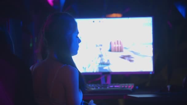 Joven mujer sexy jugando un juego en el club de juego - se da la vuelta y sacando un chicle de su boca - Metraje, vídeo