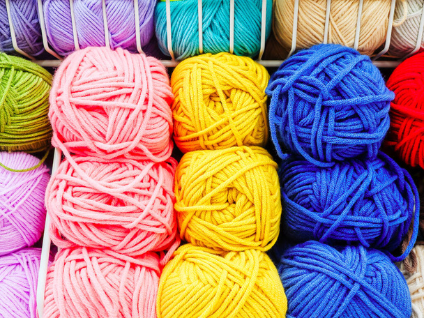 Multicolored skeins of yarn for knitting are arranged according to colors. Closeup - Photo, Image