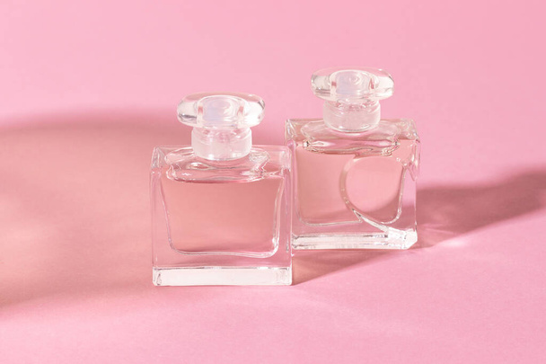 Glass perfume bottles in bright sunlight with harsh shadows. - Zdjęcie, obraz