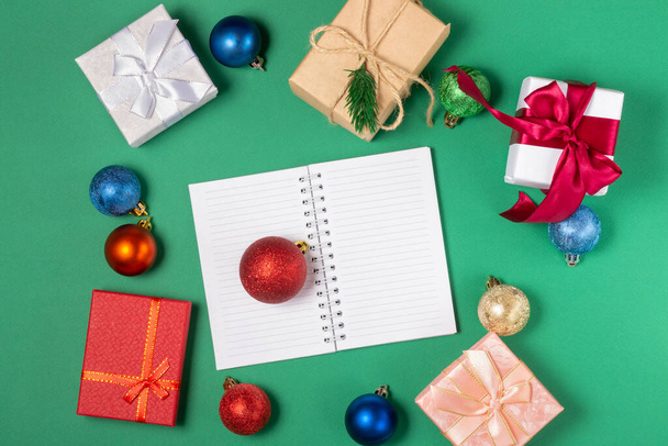 Christmas gift boxes, on a bright Christmas background with an open writing pad. Top view, holiday and Christmas concept. - Φωτογραφία, εικόνα