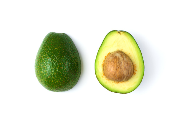 Zwei Hälften einer Avocado mit einem Stein mit Oxidationsspuren. - Foto, Bild