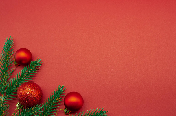 Red Christmas balls with fir branches on a red background - Photo, Image