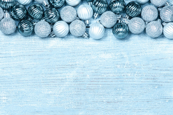 Mavi ahşap arka planda yeni yıl baloları. Renkli mücevherlerle dolu bir Noel arkaplanı. Mutlu yıllar tebrik kartı. - Fotoğraf, Görsel