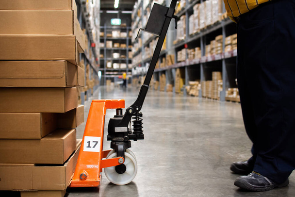Employees use pallet trucks to lift cartons in the warehouse. - Photo, Image