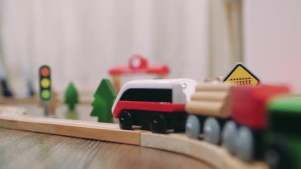 Holzspielzeugeisenbahn mit Dorf und Bahnhof im Hintergrund - Filmmaterial, Video