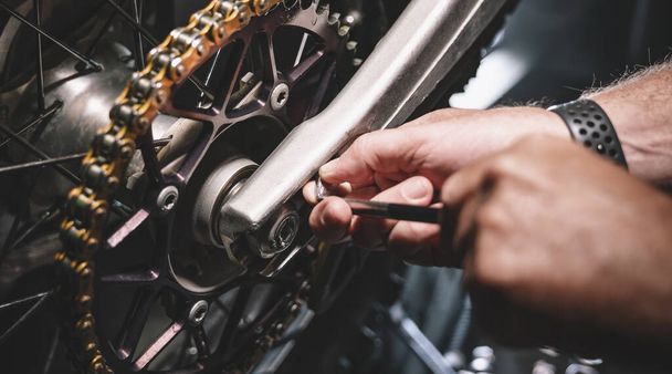 Mechanisch werken aan Motocycle in garage mechanica. Reparatie. authentieke close-up opname - Foto, afbeelding