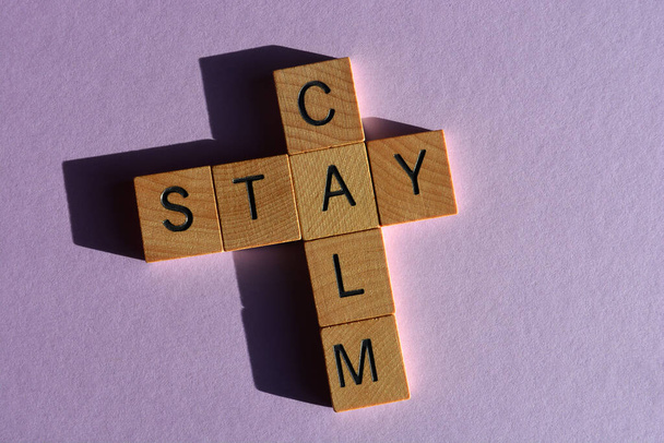 Stay Calm, words in wooden alphabet letters in crossword form isolated on purple background with copy space - Photo, Image