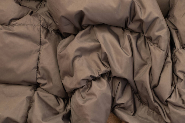dark gray fabric warm down jacket as background close-up - Photo, Image