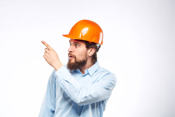 Man in orange hard hat industry engineer work professional light background - Photo, Image