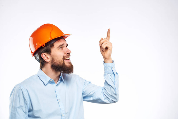Man in orange hard hat industry engineer work professional light background - Photo, Image