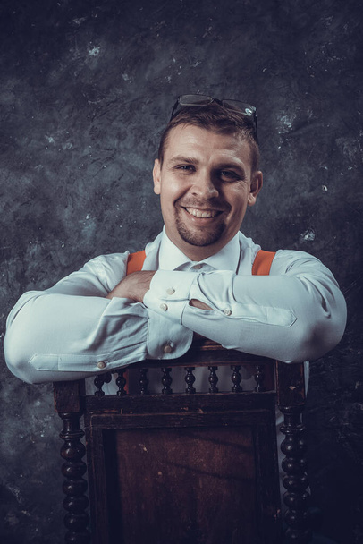 Mature businessman dressed in whire shirt with red suspenders studio portrait. - Photo, Image