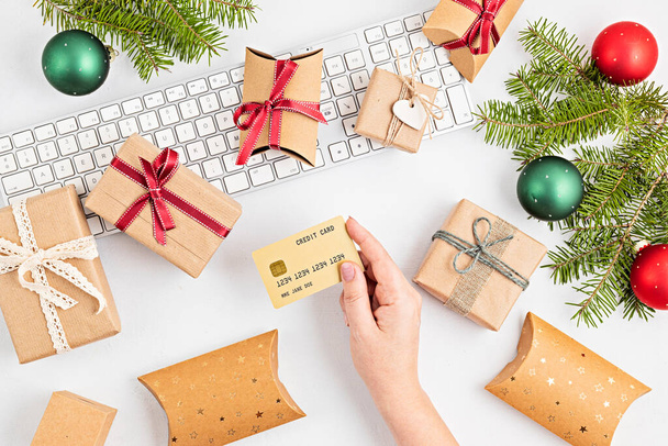 Online christmas shopping concept with gift boxes, keyboard and golden credit card. Top view, flat lay, mock up - Photo, Image