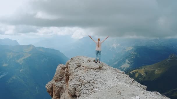 Feliz mujer libre con las manos extendidas en la parte superior de la roca - Metraje, vídeo