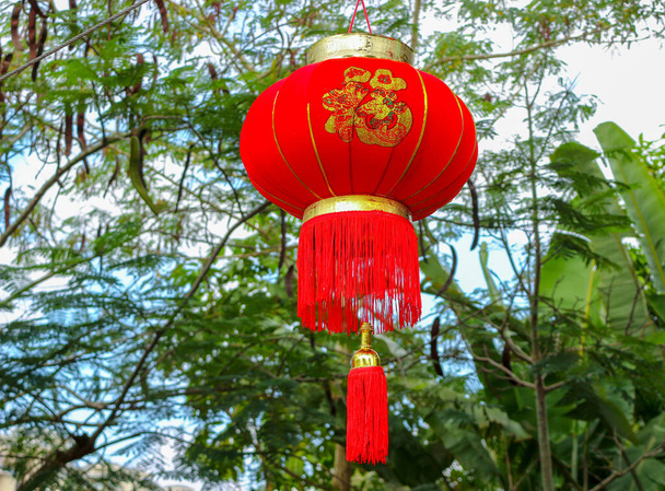 Linterna tradicional china roja del año nuevo que cuelga sobre fondo natural borroso - Foto, imagen