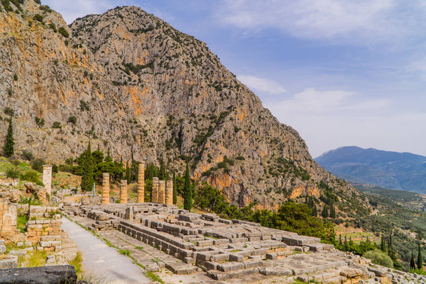 Blick auf den Apollotempel mit Bergen im Hintergrund in Delphi, Griechenland - Foto, Bild
