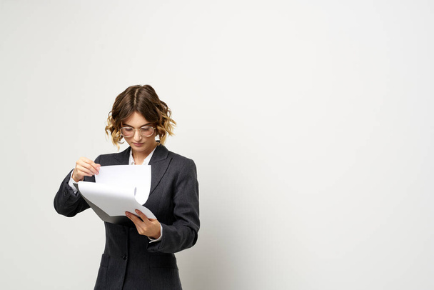 business woman in a suit with documents in hands light background curly hair hairstyle - Photo, Image