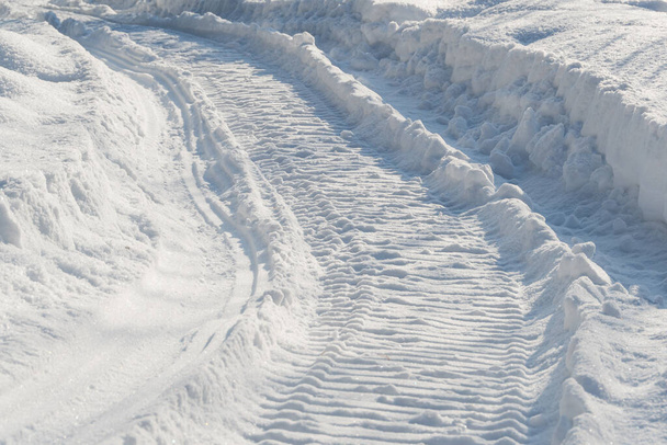 Piste di motoslitta nella neve profonda. Tracce attorciglianti di un campo innevato attraversato da motoslitte - Foto, immagini