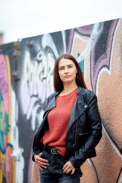 long-haired brunette against a background of street graffiti - Foto, imagen