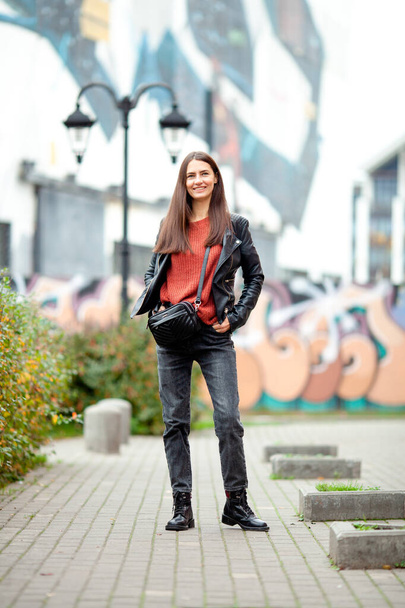 long-haired brunette against a background of street graffiti - Foto, Bild