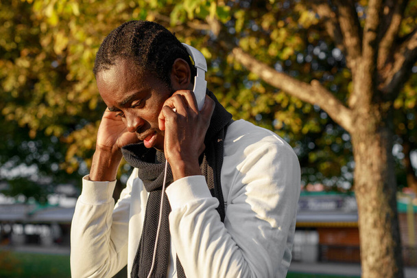 Afrykanin ze słuchawkami w parku - Zdjęcie, obraz