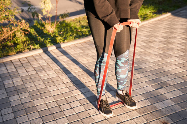 Femme avec bande élastique rouge sur les jambes - Photo, image